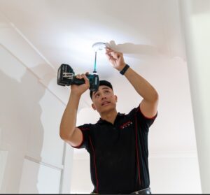 Electrician installing smoke alarm.