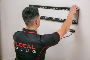 Technician installing a TV wall mount.
